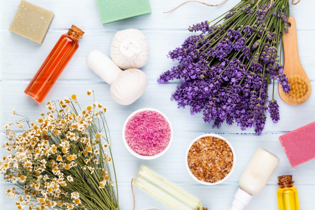 Essential oil and lavender, chamomile salt with flowers top view.