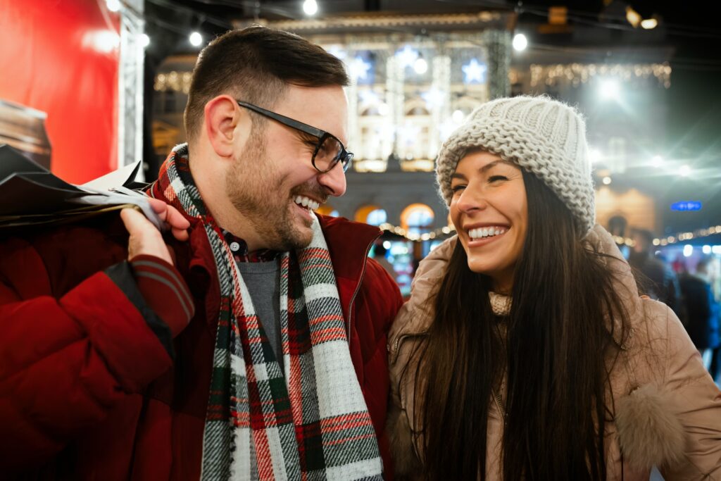 Portrait of happy couple shopping for Christmas in the city. People holiday happiness sale concept